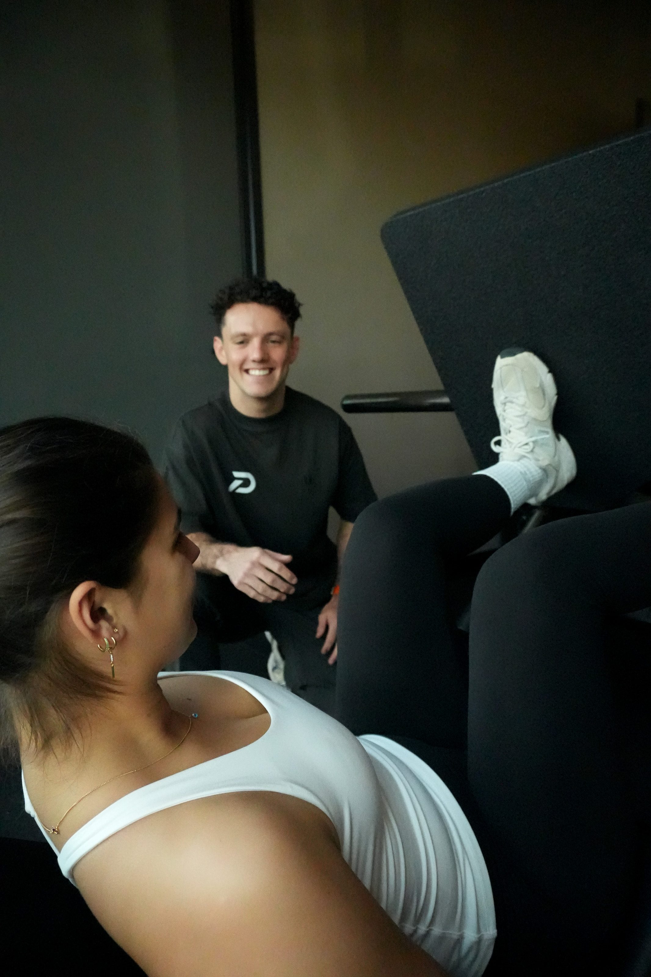 Laurens moedigt lachend een klant aan op de leg press