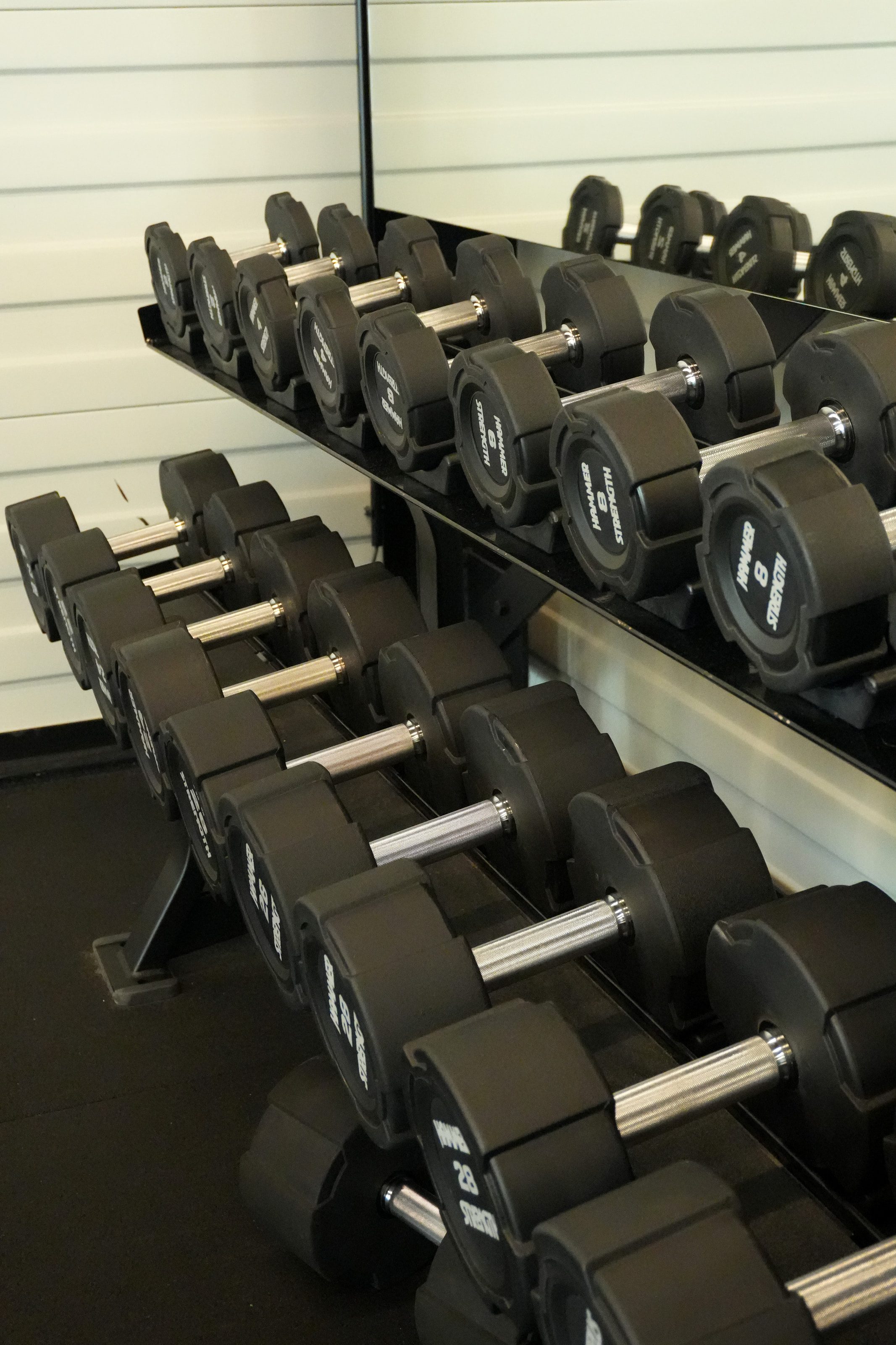 Een rek met dumbbells voor een spiegelwand in Fitness4All