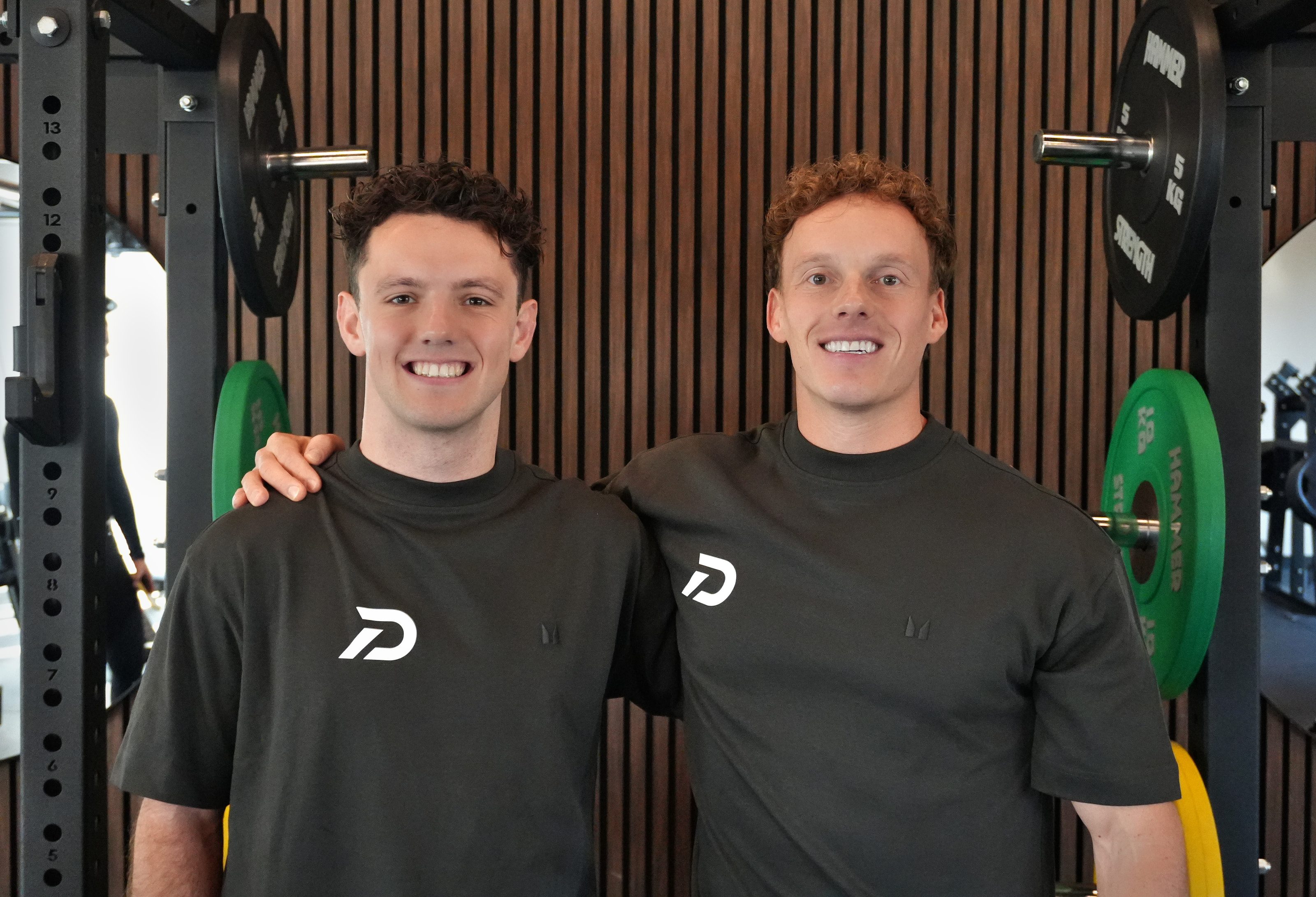 Laurens en Vince naast elkaar in Fitness4All, allebei in een DRIVEN-shirt